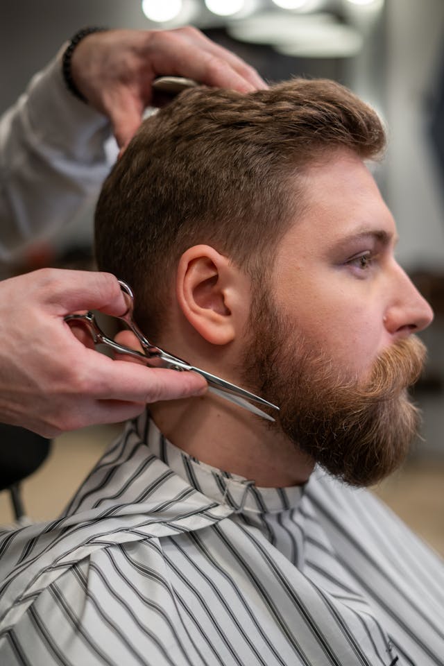 man in barbers chair getting beard trimmed