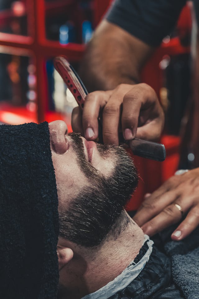 man getting razor shave in barber's chair